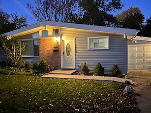 A residential house with a garage, a front door with a light, and a mailbox.