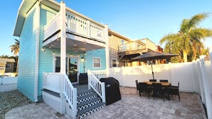 A two-story house with a covered patio area, outdoor seating, and a grill. - Seaglass Shores, Steps to the Beach (Cape Canaveral)