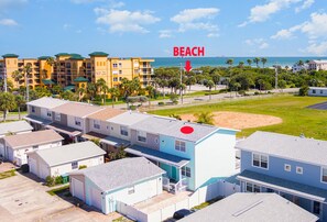 Zona residencial frente a la playa con varias casas, una playa de arena y vistas al océano.