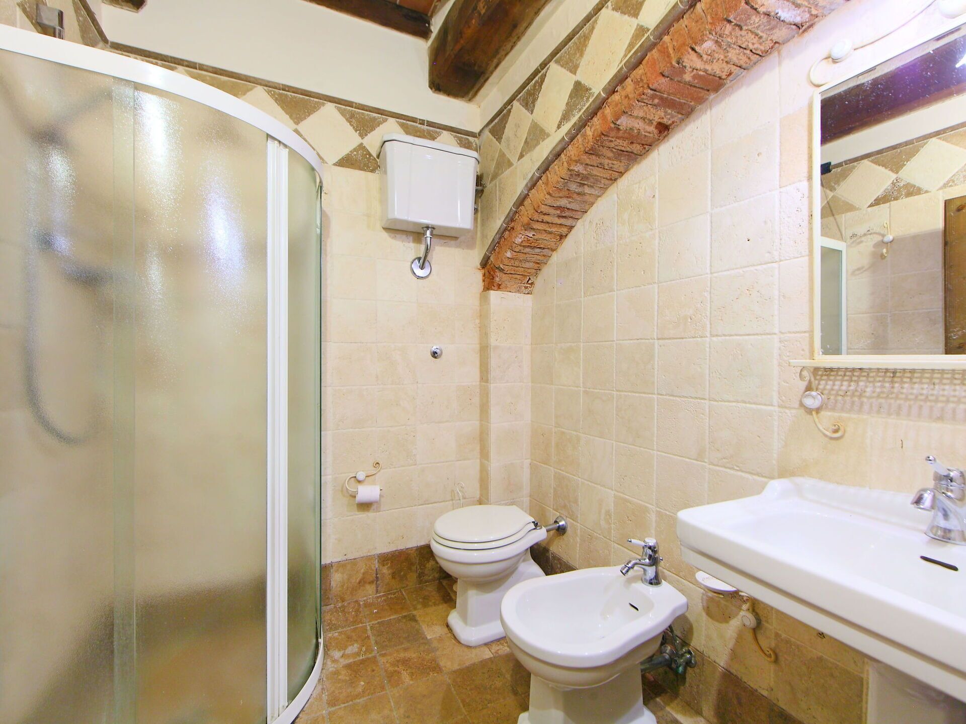 Un bagno completo con doccia, toilette, bidet e lavandino.