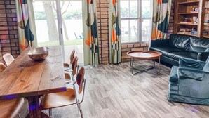 Ein gemütliches Wohnzimmer mit einem Holzesstisch, St ühlen, einem Ledersofa und einem kleinen Beistelltisch.