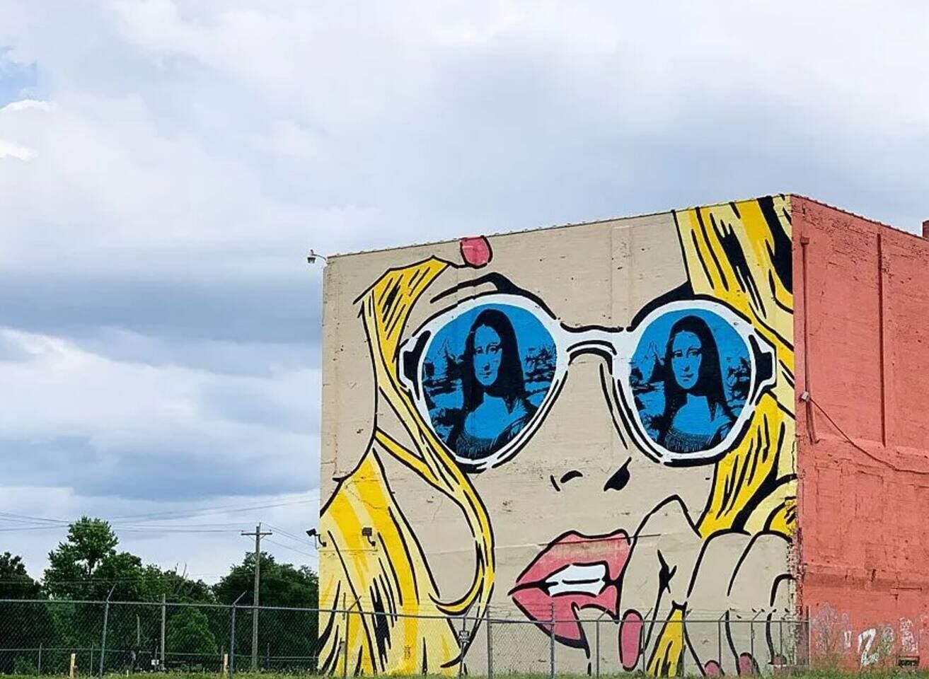 A mural of a woman with sunglasses on a building.