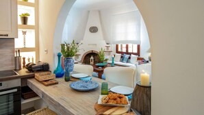 A kitchen with a wooden countertop, a dining area with a white sofa, and a brick fireplace. - Villa Eleni Paxos in Gaios (Paxos)