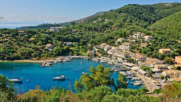 A coastal village with houses, a marina, and boats. - Paola House in (Corfu)