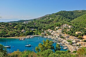 A coastal village with houses, a marina, and boats.