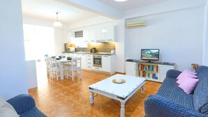 A modern living room with a sofa, a coffee table, and a television. - Paola House in (Corfu)