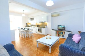 Ein modernes Wohnzimmer mit einer Couch, einem Couchtisch und einem Fernseher.