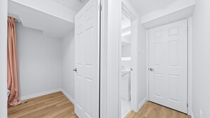 A room with white walls, a wooden floor, and two white doors. - Charming 1-bed basement, WI-fi & Pull Out Sofa (Barrie)