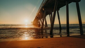 A pier extending into the ocean with the sun setting in the background. - Modern 2BDRM/2BATH Beachfront Condo in Hermosa (Hermosa Beach)