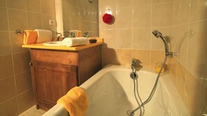 A bathroom with a bathtub, a wooden vanity, a mirror, and a towel rack. - Beautiful apartment for 8 people with pool, WIFI, TV, terrace and pets allowed (Vallandry)