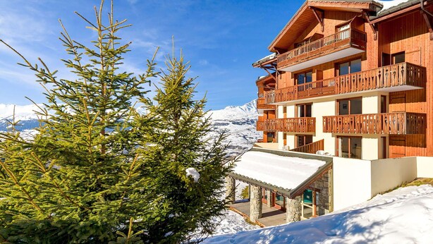 A wooden chalet with balconies, surrounded by snow and evergreen trees. - Beautiful apartment for 8 people with pool, WIFI, TV, terrace and pets allowed (Vallandry)
