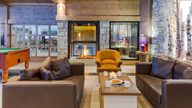 A cozy lounge area with a fireplace, leather sofas, and a pool table. - Lovely apartment for 6 people with WIFI, pool, TV, terrace and pets allowed (Les Gets)