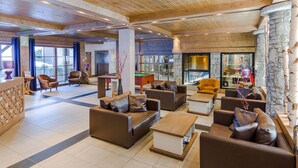 A spacious lobby with multiple seating areas, a pool table, and a stone fireplace. - Lovely apartment for 6 people with WIFI, pool, TV, terrace and pets allowed (Les Gets)