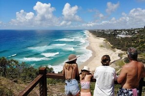 A coastal view from a wooden deck overlooking a beach with waves crashing onto the shore. - Top 1 Sunshine Beach Family Retreat (Sunshine Beach)