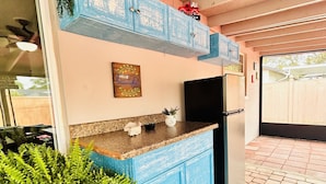 A kitchen with blue cabinets, a refrigerator, and a countertop with decorative items. - Frenzy for the old w/heatedpool in a safe and quite neighborhood! (Tampa)