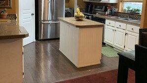 A modern kitchen with a central island, stainless steel appliances, and white cabinetry. - Great family getaway with large entertaining deck. (Crescent Lake)