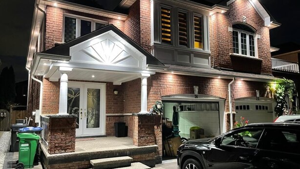 A two-story house with a garage, a covered front porch, and a driveway. - Spacious 4 Bdrm House in Brampton (Brampton)