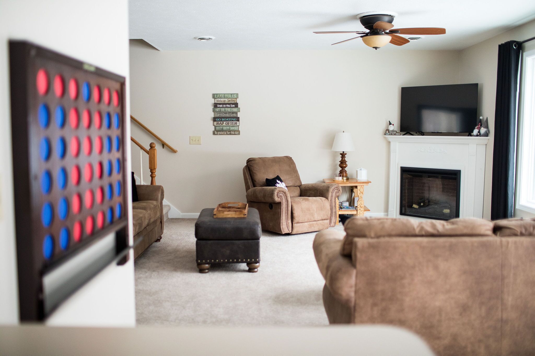 Una sala de estar con chimenea, televisión y ventilador de techo.
