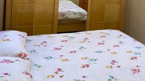 Un dormitorio con cama, un armario de madera y un espejo.