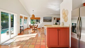 A spacious kitchen with a large island, a dining area with a view of the outdoors, and a modern refrigerator. - Foothills Southwest Sanctuary w/ Pool & Views (Tucson)