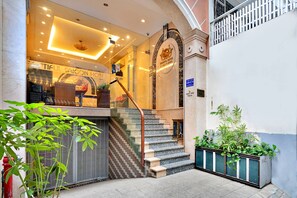 A hotel entrance with a staircase leading to the lobby, a glass door, and a sign indicating the hotel name. - S79 Boutique Hotel by hostify (Ho Chi Minh City)