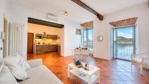 Un vaste espace de vie comprenant un canapé, une table basse et donnant sur un balcon.