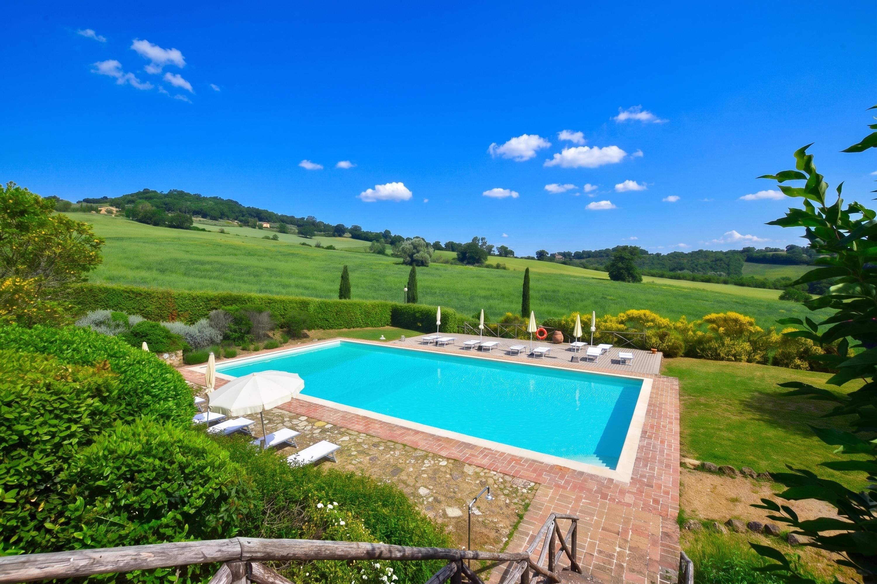 Une piscine rectangulaire dont les bords sont recouverts de carreaux, entourée d’une terrasse en briques.