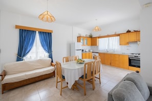 Un espace de vie compact comprenant un coin repas, une kitchenette et un lit.
