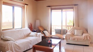 A spacious living room with a wooden ceiling, two sofas, a coffee table, and large windows with curtains. - Villa Majestic in Agia Marina Chrysochous (Ayia Marina Chrysochous)