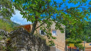 Una casa de piedra con encanto rústico, que presenta una pared de piedra y una puerta de madera.