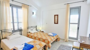 Een hotelkamer met twee bedden, een bureau en een stoel.