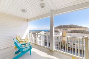 A balcony with a view of the beach and buildings.