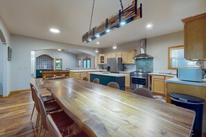 Enjoy cooking in this well-equipped kitchen with a central island, stainless steel appliances, and a large dining table.