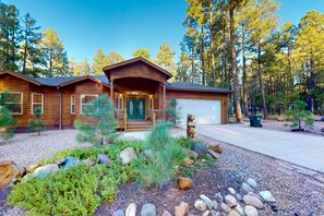 Escape to a serene wooded retreat with a cozy cabin, a welcoming porch, and a beautifully maintained garden.