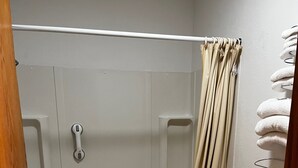 A bathroom with a bathtub, toilet, and shower curtain. - Furnas County Lodging (Beaver City)