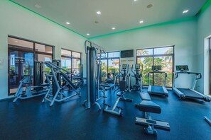 Un gimnasio con diferentes máquinas de ejercicio, bancos y cintas de correr.
