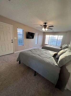 Relax in this cozy space with a single bed, ceiling fan, and wall-mounted TV.