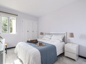 Relax in this serene bedroom with a large bed, bedside lamps, and a spacious wardrobe.