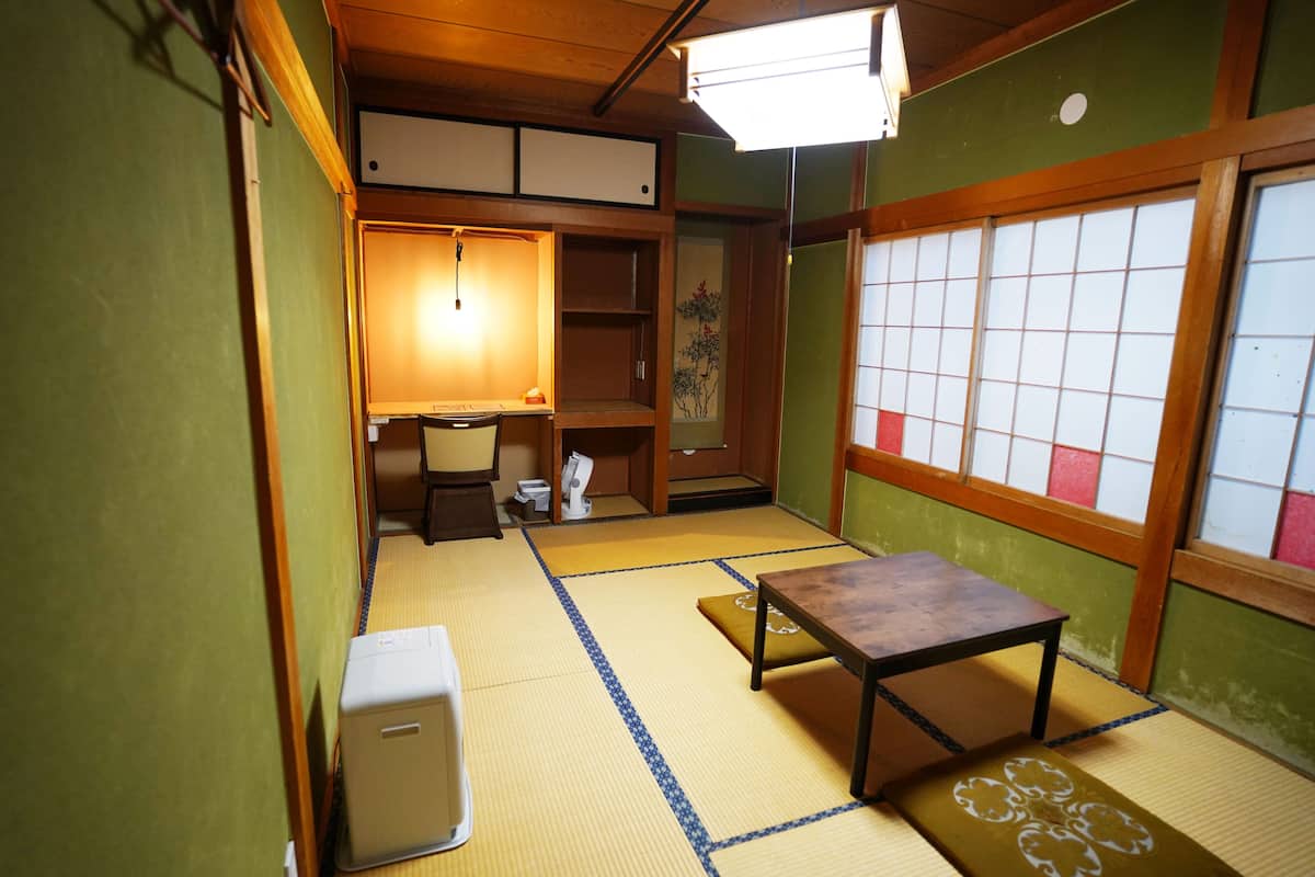 Ett traditionellt japanskt rum med tatamimattor på golvet, ett lågt träbord och en shoji-skärm.
