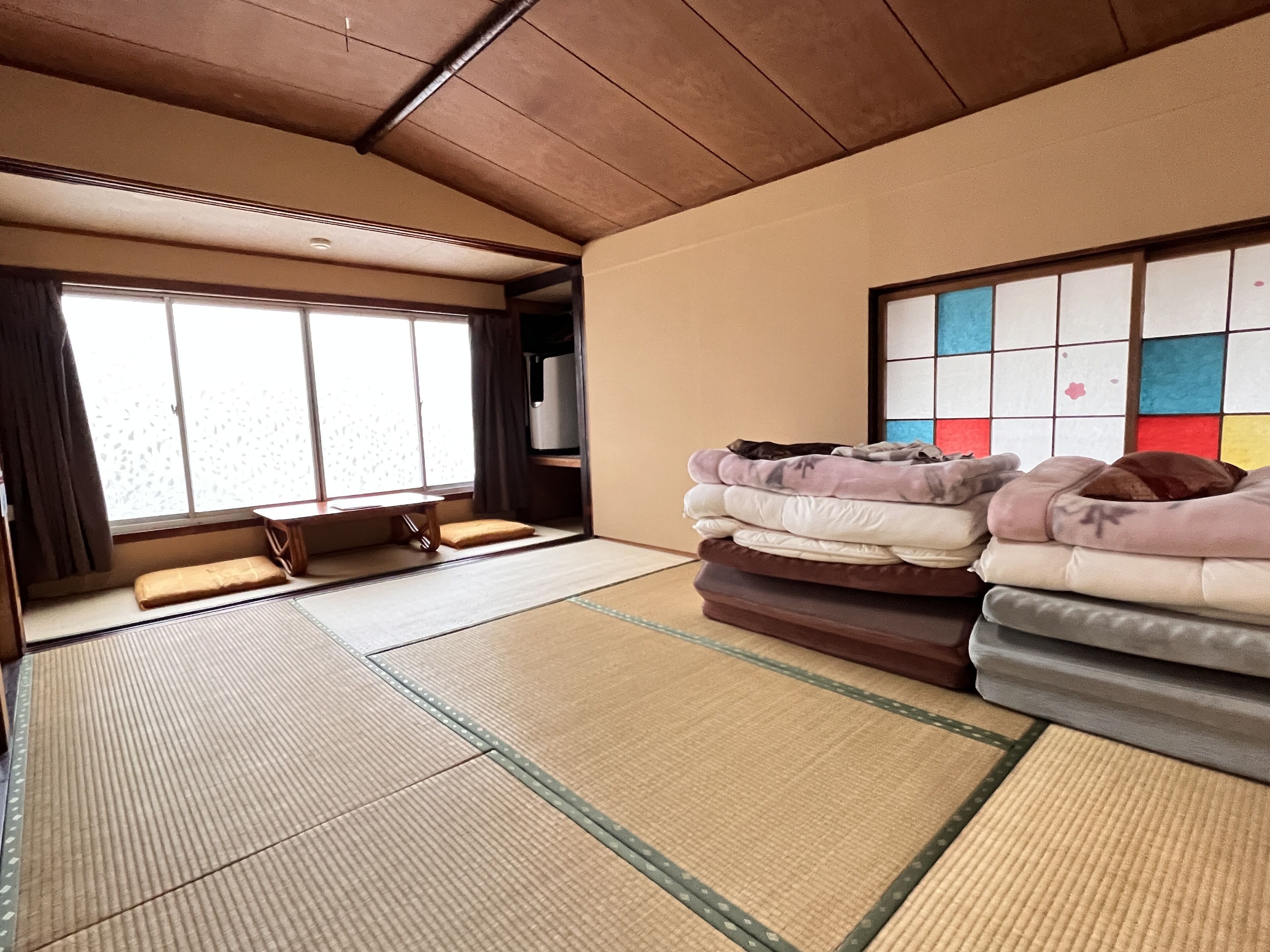 A tatami mat room with futons and a shoji screen.