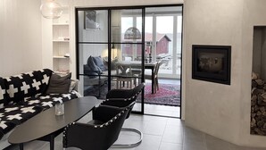 A modern interior with a dining area, a sofa, and a view of a wooden structure by the water. - Fantastic location next to Lake Sommen (Ydre)