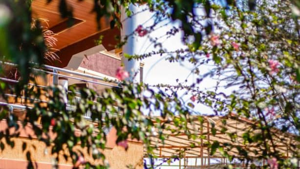 A building with a covered outdoor area, a staircase, and a table set up for dining. - Nyungwe Hotel by Savany Investments (Kigali)