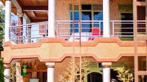 A two-story building with a balcony on the upper floor, columns, and a covered entrance area. - Nyungwe Hotel by Savany Investments (Kigali)