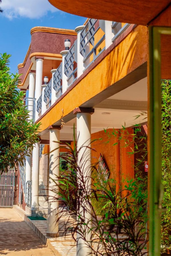 A building with a covered outdoor area, columns, and a staircase.