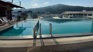 A swimming pool with a view of mountains in the background. - 77 Patong Hotel & Spa (Patong)
