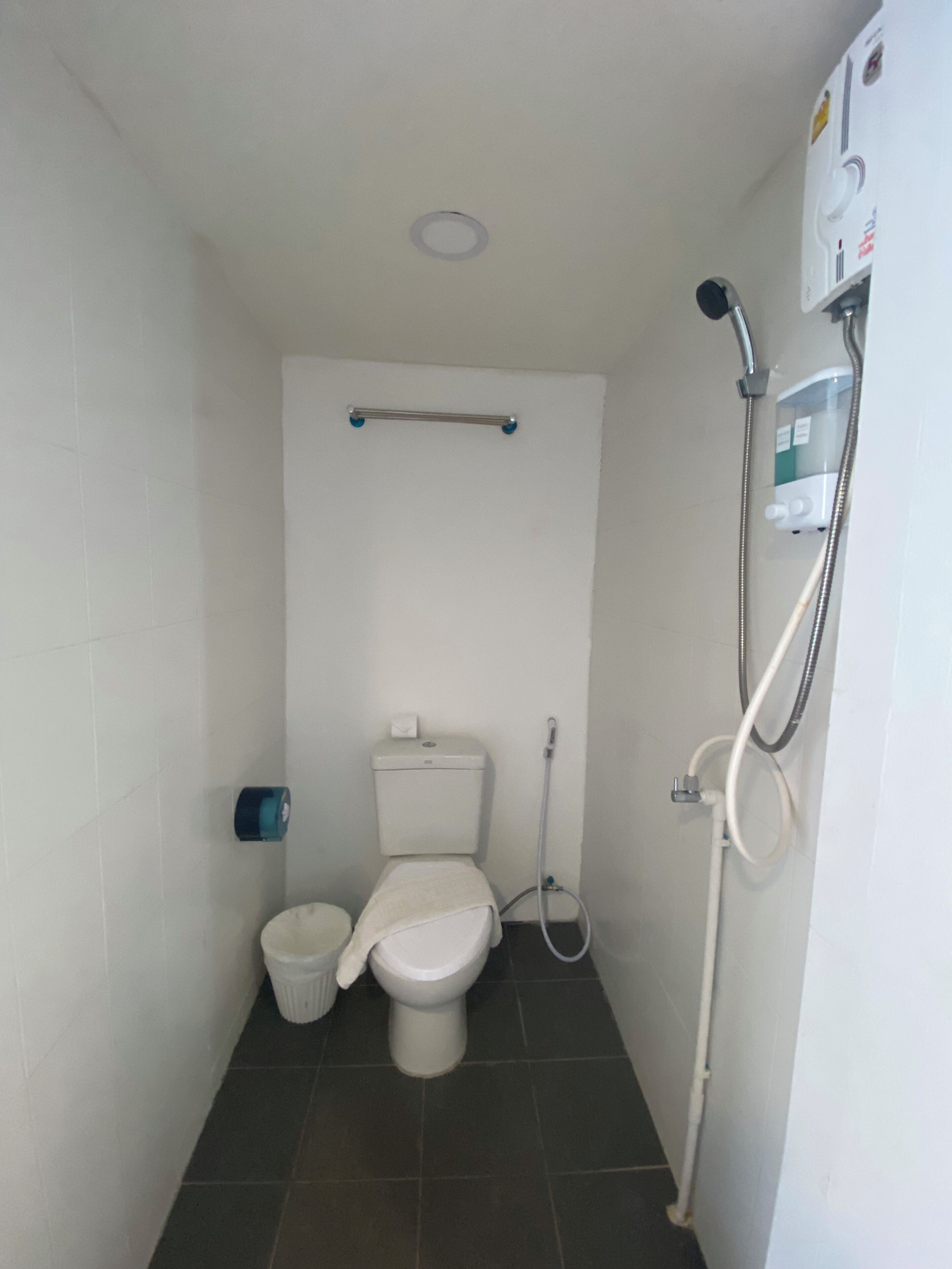 A small, compact bathroom with a toilet, bidet, and shower.