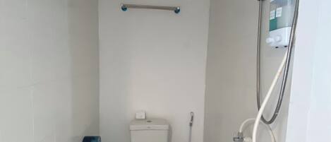 A small, compact bathroom with a toilet, bidet, and shower.