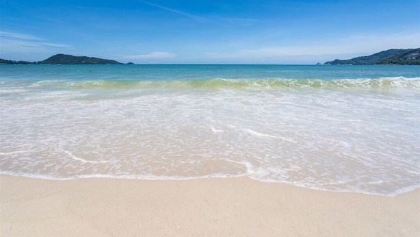A beach with clear blue water and gentle waves. - 77 Patong Hotel & Spa (Patong)