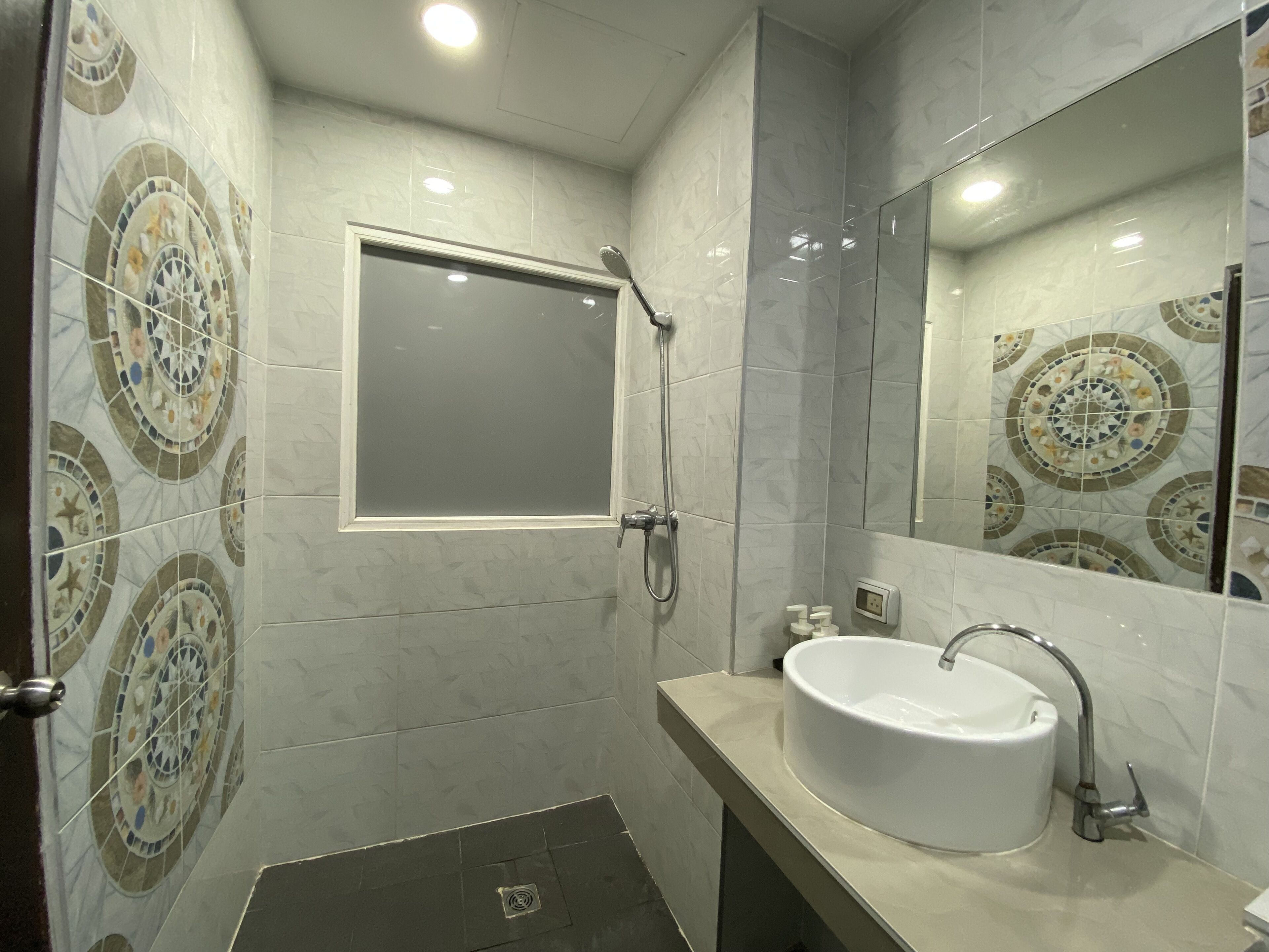 A bathroom with a shower, a sink, and a mirror.