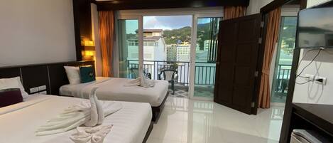 Habitación de hotel con dos camas, un balcón y vistas.